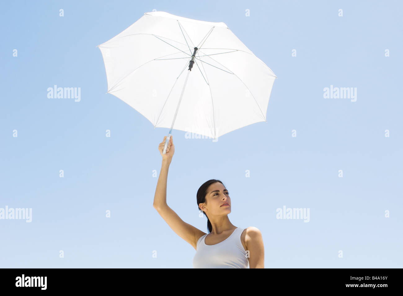 Woman holding up parasol, looking away Stock Photo