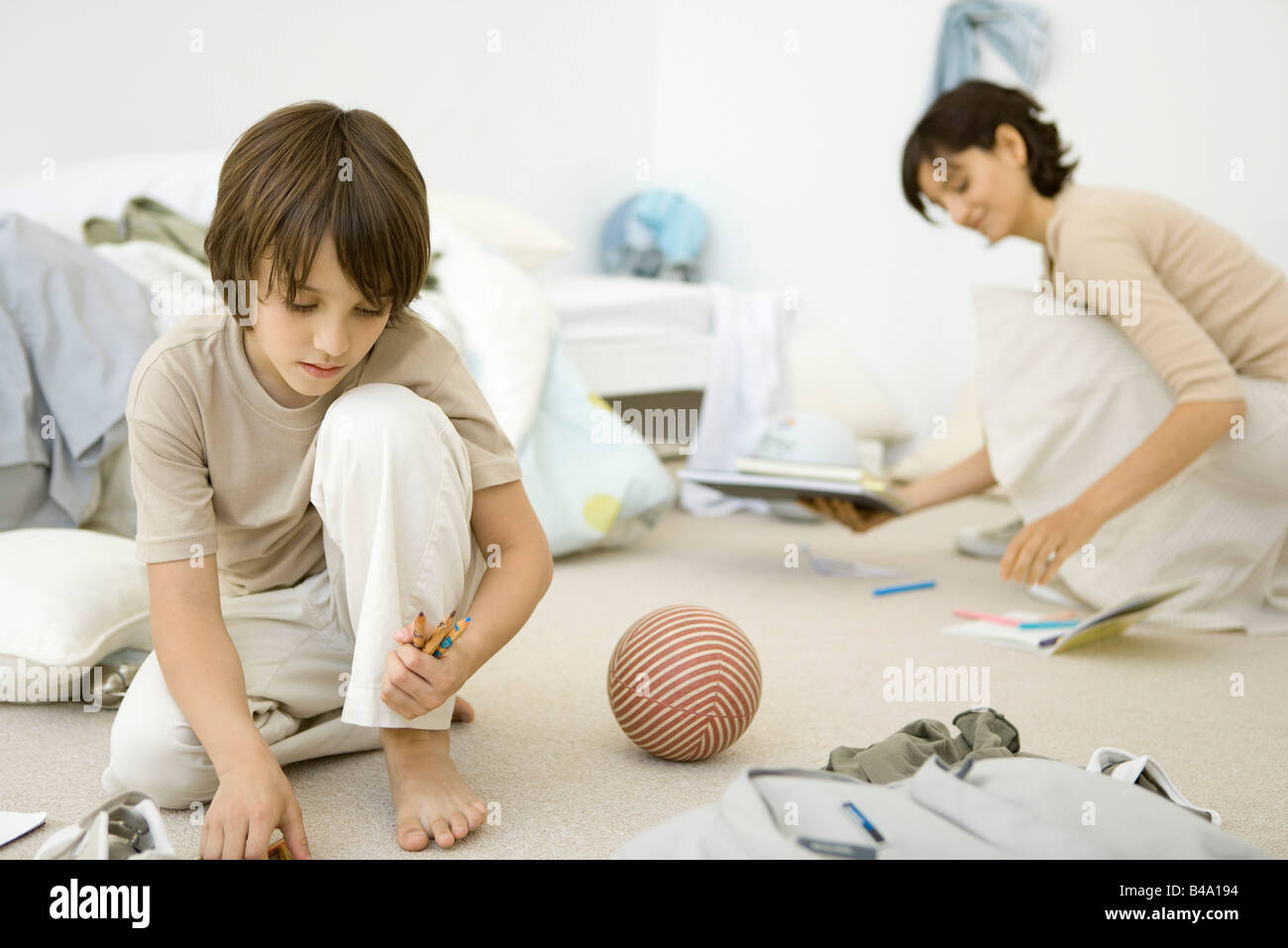 Mother and son cleaning messy bedroom together Stock Photo Alamy