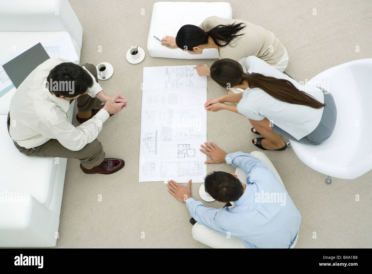 Team of professionals looking at blueprint together, overhead view Stock Photo