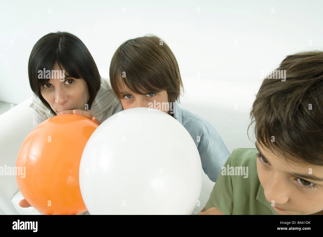 Mother and sons inflating balloons Stock Photo