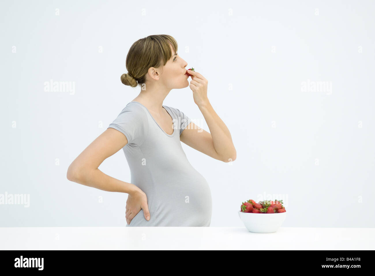 Pregnant woman eating strawberries, side view Stock Photo Alamy