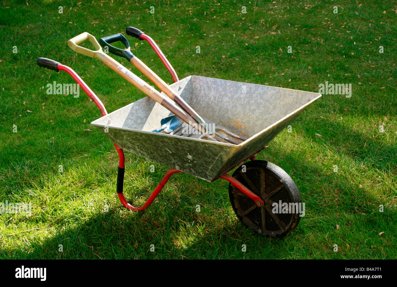 Garden wheelbarrow with tools. Stock Photo