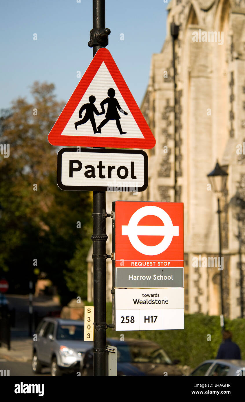 A road traffic triangular Patrol sign and bus stop sign at Harrow School in Harrow on the Hill. Stock Photo