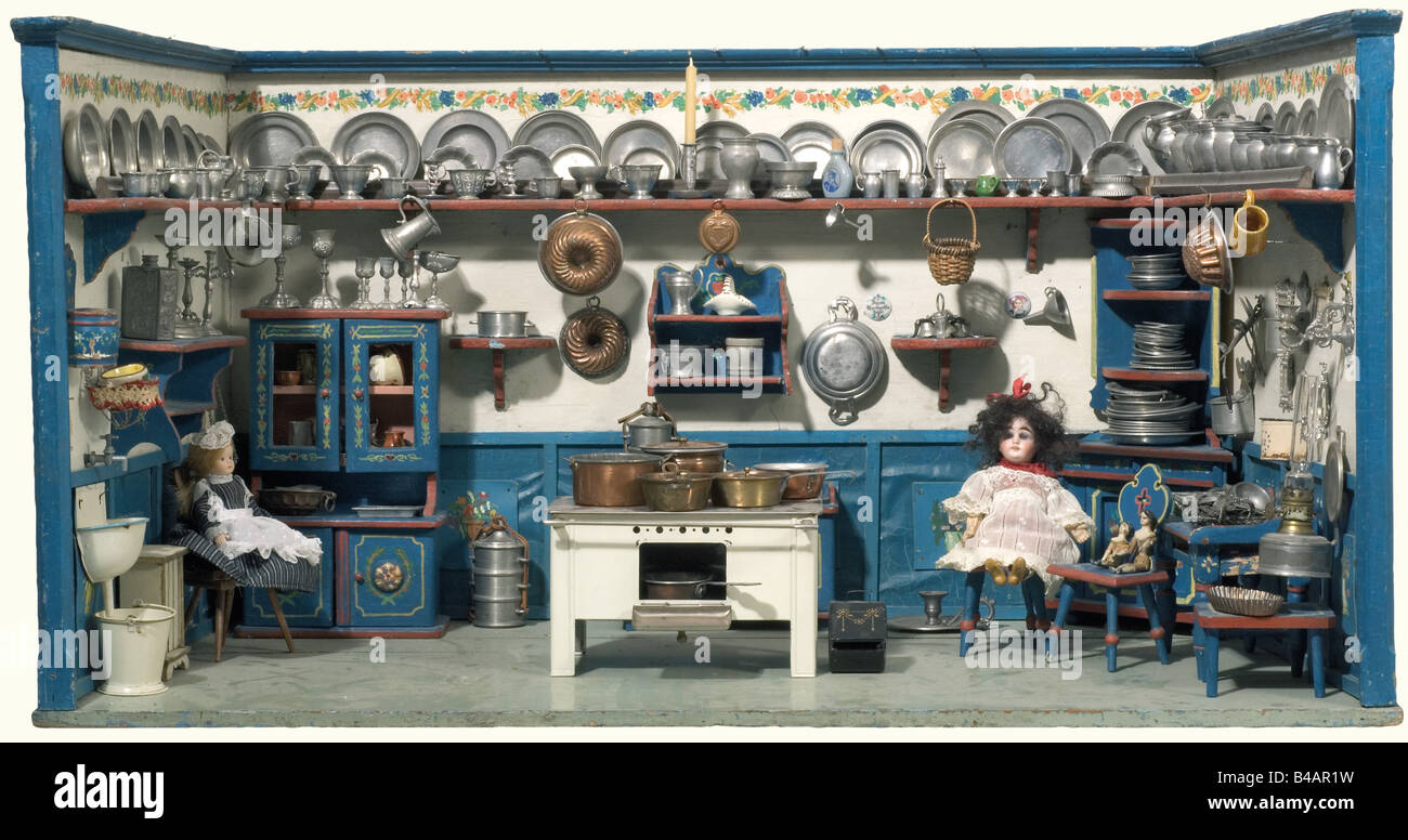 A doll's kitchen, German, circa 1900 A slightly tapered kitchen, open in the front with surrounding base board and shelf. Wooden furniture with multicoloured painting, a later two burner metal stove (stovepipe and stove top missing). Richly outfitted with accessories (most from the 19th century) mainly pewter. There are also two dolls with porcelain heads (one which can close its eyes) and one small wooden doll from around 1850, the second doll pictured on the left has been withdrawn from the lot. Dimensions 89.5 x 48 x 46.5 cm. historic, historical, 1900s, 20t, Stock Photo