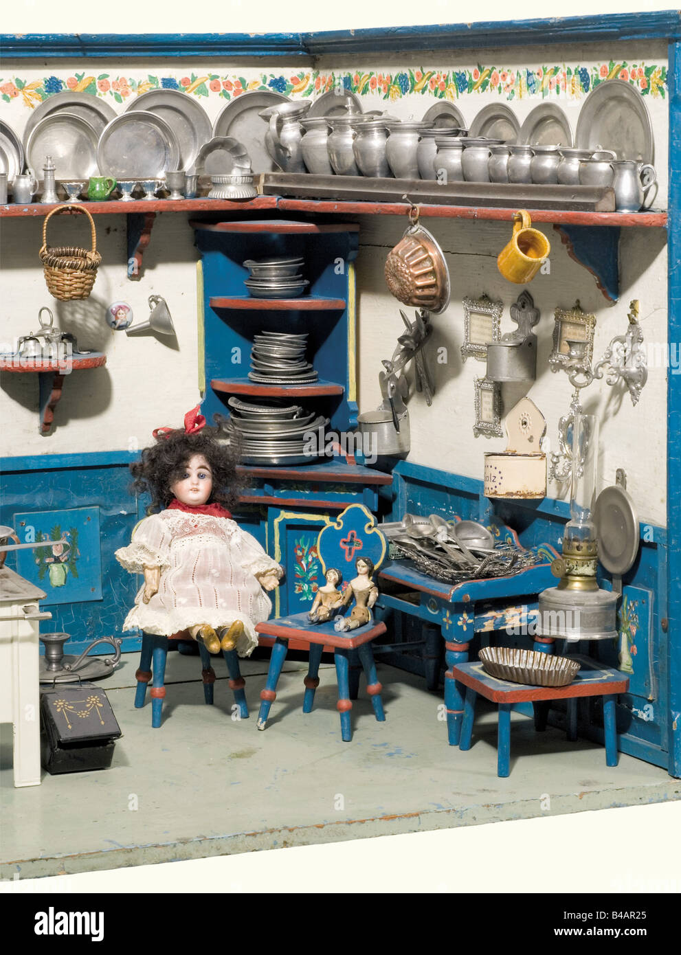 A doll's kitchen, German, circa 1900 A slightly tapered kitchen, open in the front with surrounding base board and shelf. Wooden furniture with multicoloured painting, a later two burner metal stove (stovepipe and stove top missing). Richly outfitted with accessories (most from the 19th century) mainly pewter. There are also two dolls with porcelain heads (one which can close its eyes) and one small wooden doll from around 1850, the second doll pictured on the left has been withdrawn from the lot. Dimensions 89.5 x 48 x 46.5 cm. historic, historical, 1900s, 20t, Stock Photo