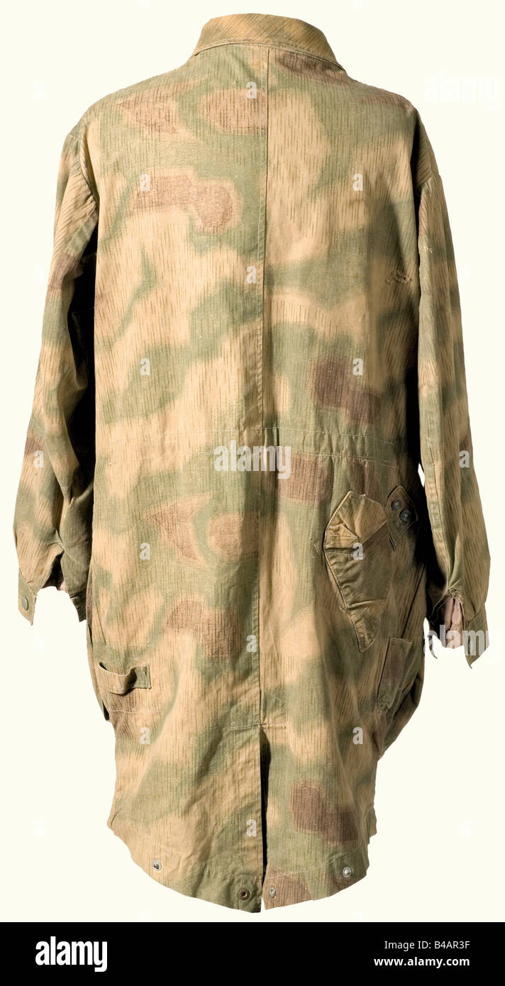 A paratrooper's jump smock, so-called "bone bag" in swamp camouflage 3rd  model with the camouflage printed on one side. Continuous button flap with  six granulated metal buttons (two missing). The hip pockets
