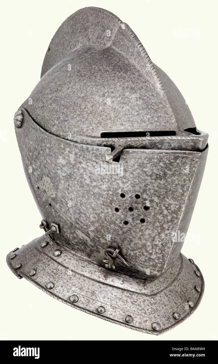 A German close helmet, circa 1580. Skull forged in one piece with a high corded comb and a riveted gorget. A two-piece movable visor secured by a hook latch. Ventilation holes on one side. Hook-latched bevor riveted to the gorget, which has turned under rims. Minimal soft-solder repairs. Height 31 cm. historic, historical, 16th century, defensive arms, weapons, arms, weapon, arm, fighting device, object, objects, stills, clipping, clippings, cut out, cut-out, cut-outs, utensil, piece of equipment, utensils, plating, armour-plating, armour, armor, reactive armou, Stock Photo