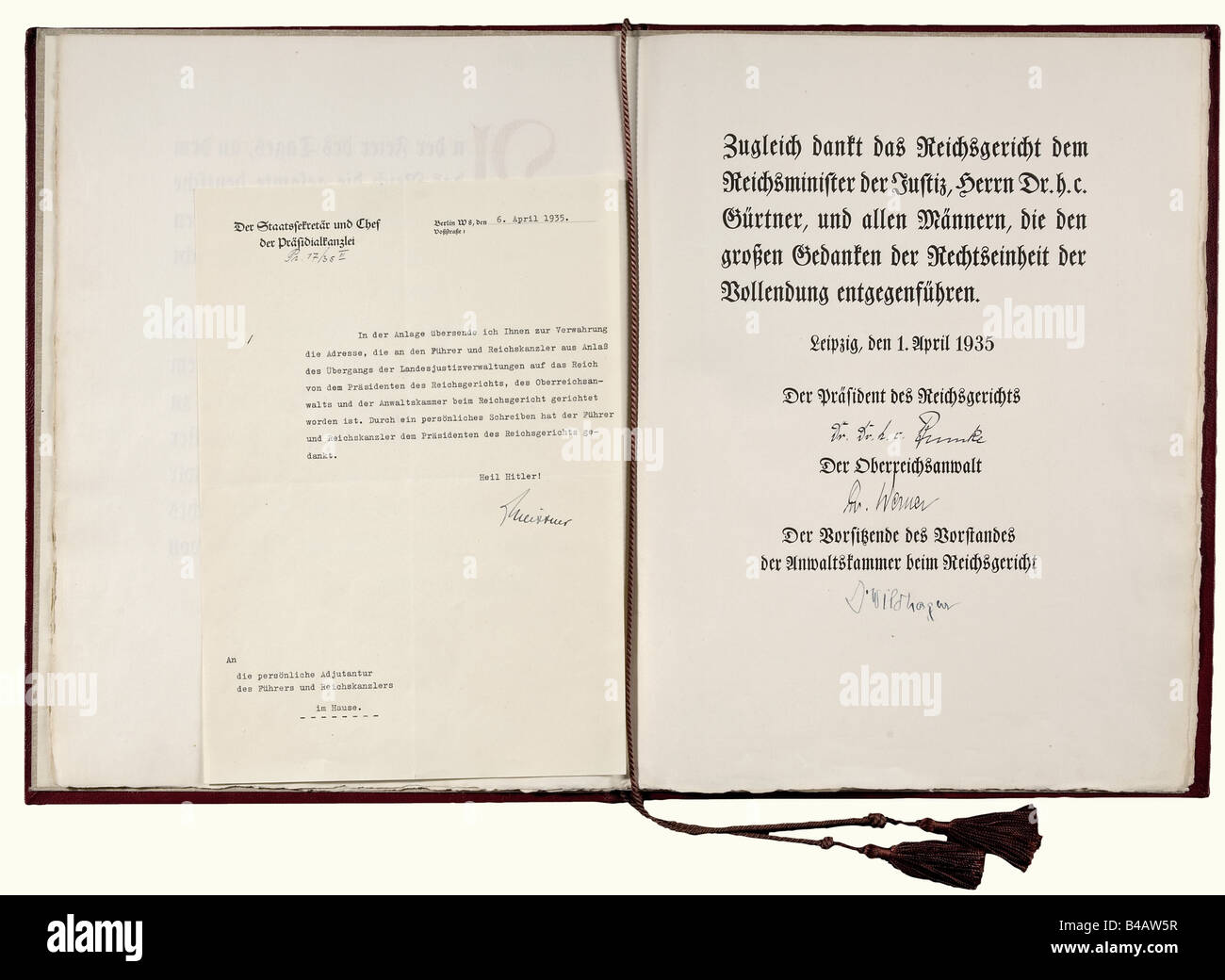 Adolf Hitler - a certificate of thanks of the Reichscourt Leipzig., Two-page printed text thanking for the 'Drittes Gesetz zur Überleitung der Rechtspflege auf das Reich' from 24th January 1935, a law which made the judicial authorities of the states subordinate to the Reichscourt. Issued in Leipzig, 1st April 1935 and signed by the President of the Reichscourt Dr. h.c. Erwin Bumke, the Supreme Attorney of the Reich Dr. Werner and the Chairman of the Chamber of Lawyers Dr. Wildhagen. Red leather folder with gold imprinting. 39 x 29.5 cm. Additionally the cover , Stock Photo