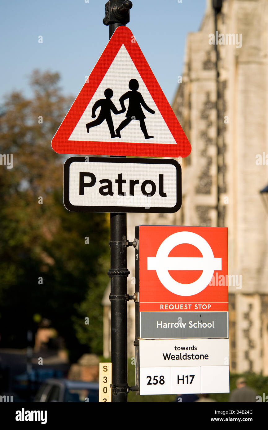 A road traffic triangular Patrol sign and bus stop sign at Harrow School in Harrow on the Hill. Stock Photo