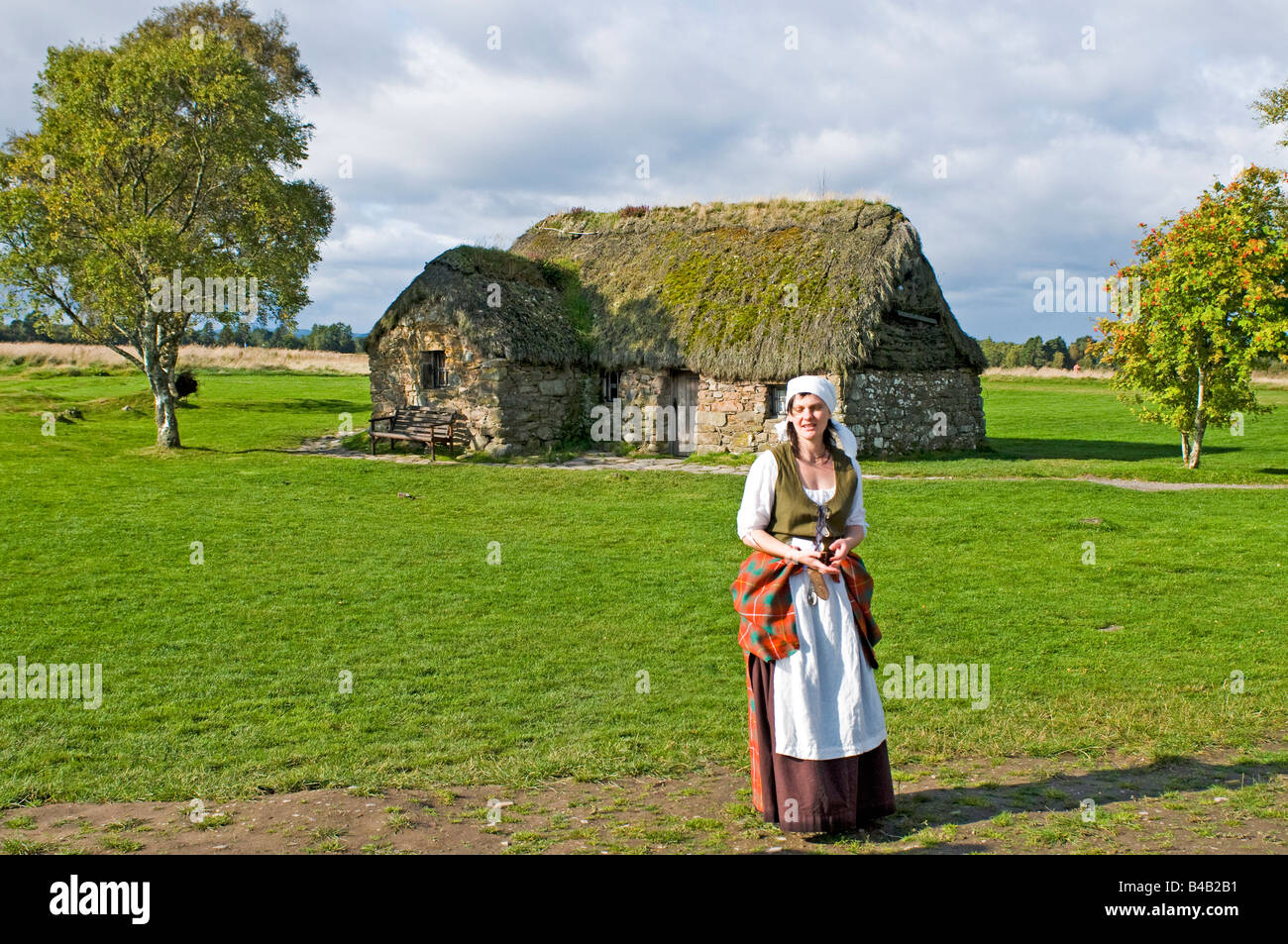 Young girl in traditional Highland dress by the original farmhouse of Leanach on the site of the Culloden Battlefield Inverness Stock Photo