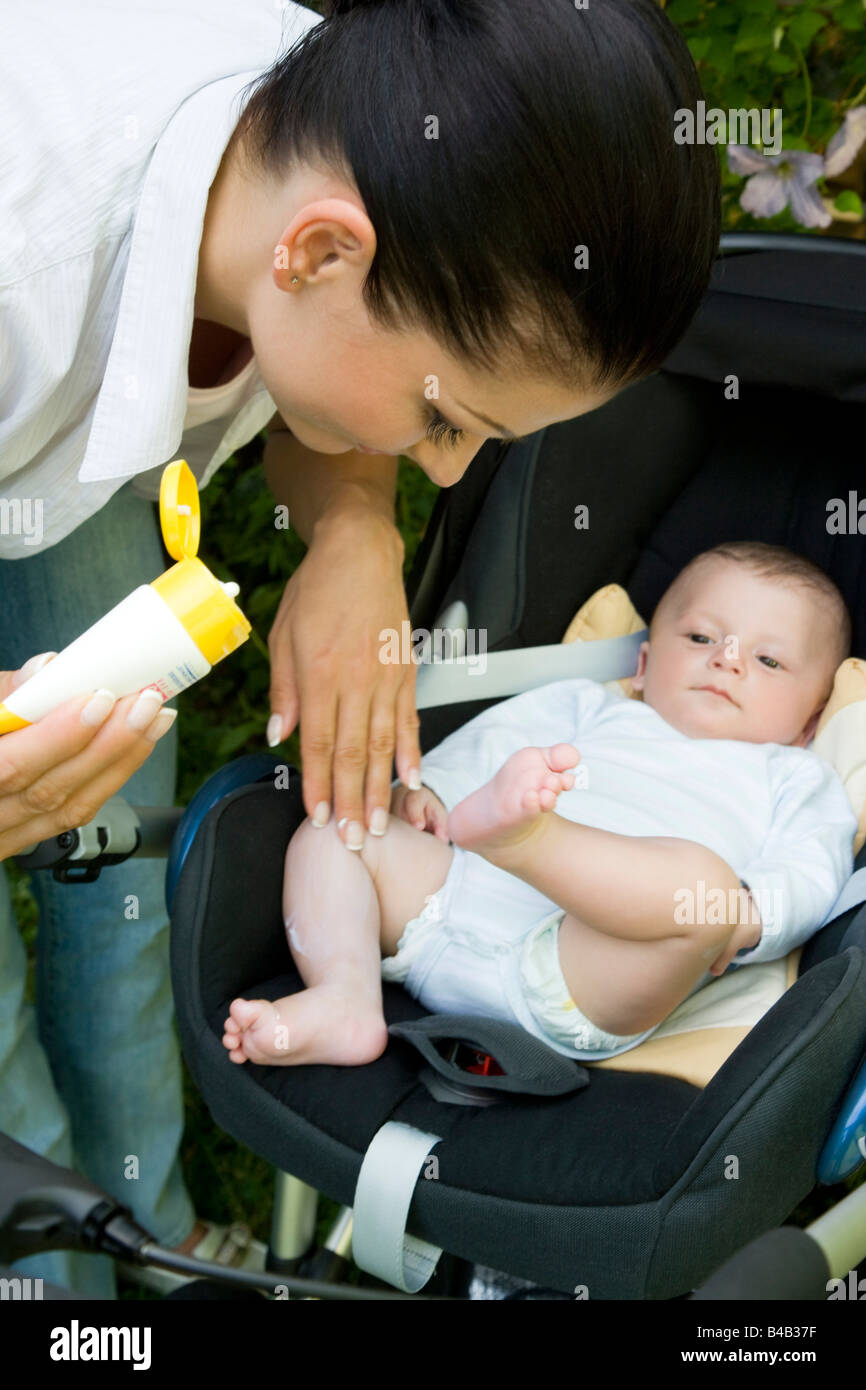 mum putting suncream on baby's body Stock Photo Alamy