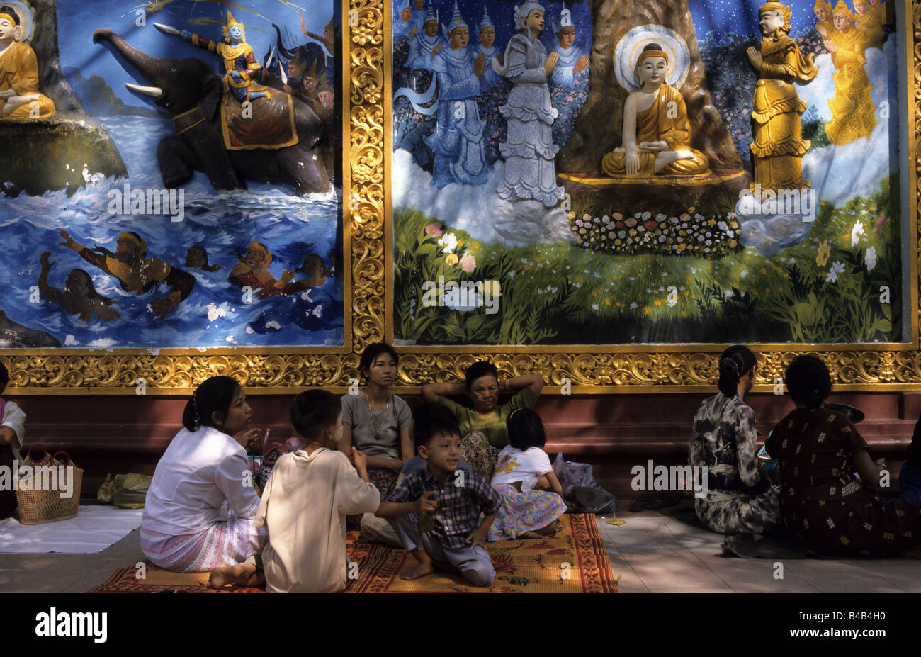 Families in front of wall paintings in the Shwedagon Pagode, Yangon, Union of Myanmar Stock Photo