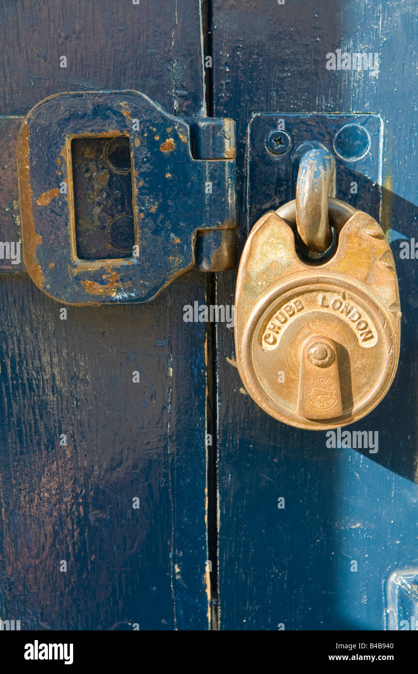 Padlock and shackle on a wooden door Stock Photo