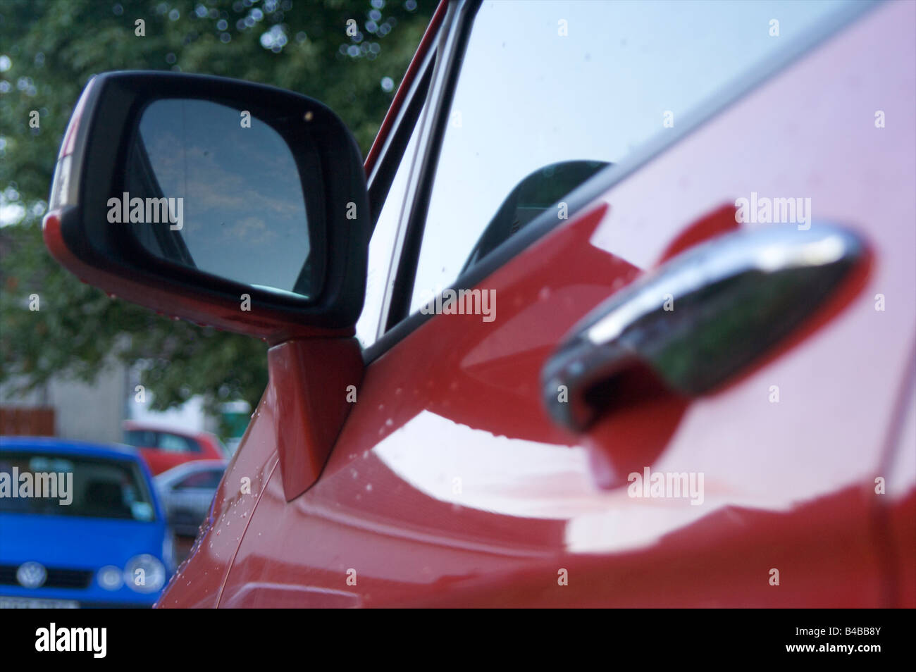 car honda red passenger side handle mirror shine reflection Stock Photo