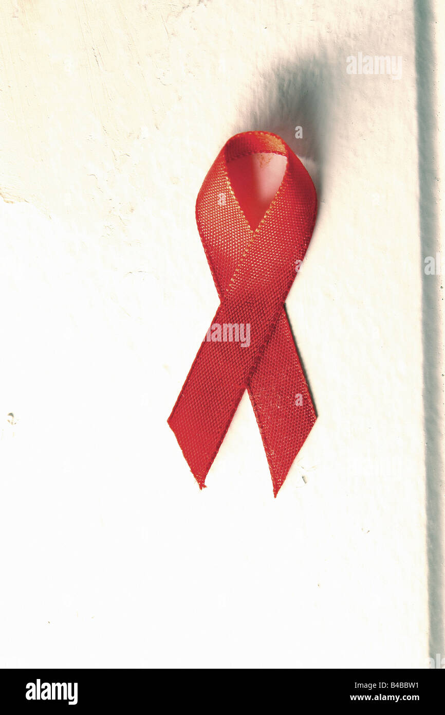 Still Life of Red AIDS Ribbon against a White Wall Copy Space Stock Photo