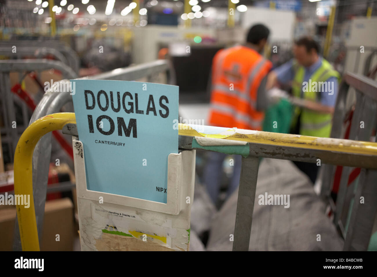 Nightshift postal workers sort through destination trolley bins inside