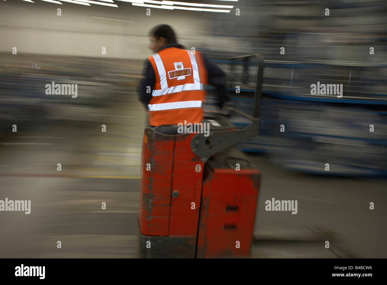 Speeding postal worker in the processing depot of Royal Mail's DIRFT logistics park in Daventry, Northamptonshire England. Stock Photo