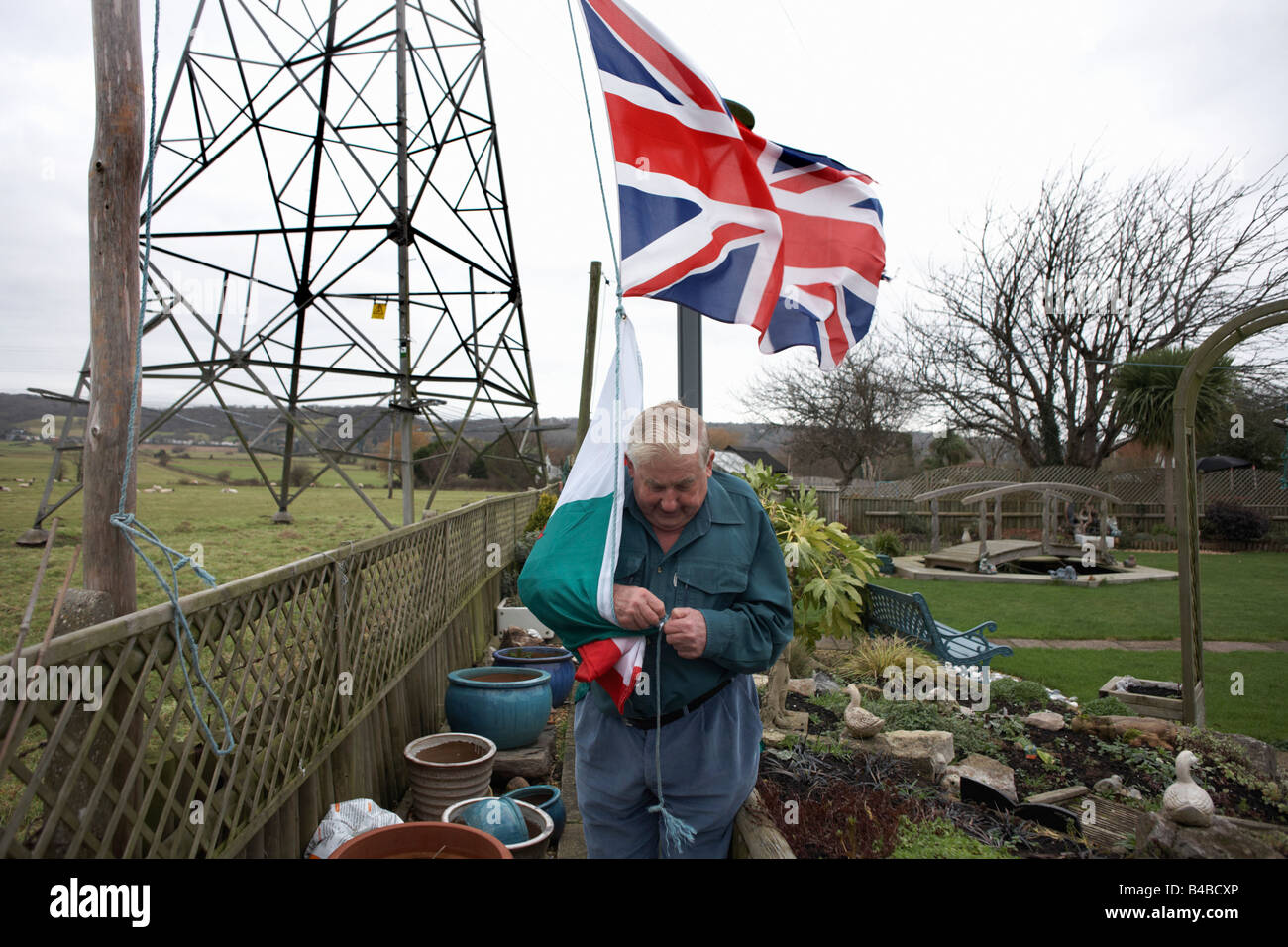 Patriotic pensioner Ivor Dowling attaches the Welsh flag beneath the Union Jack to fly in his back Somerset garden Stock Photo