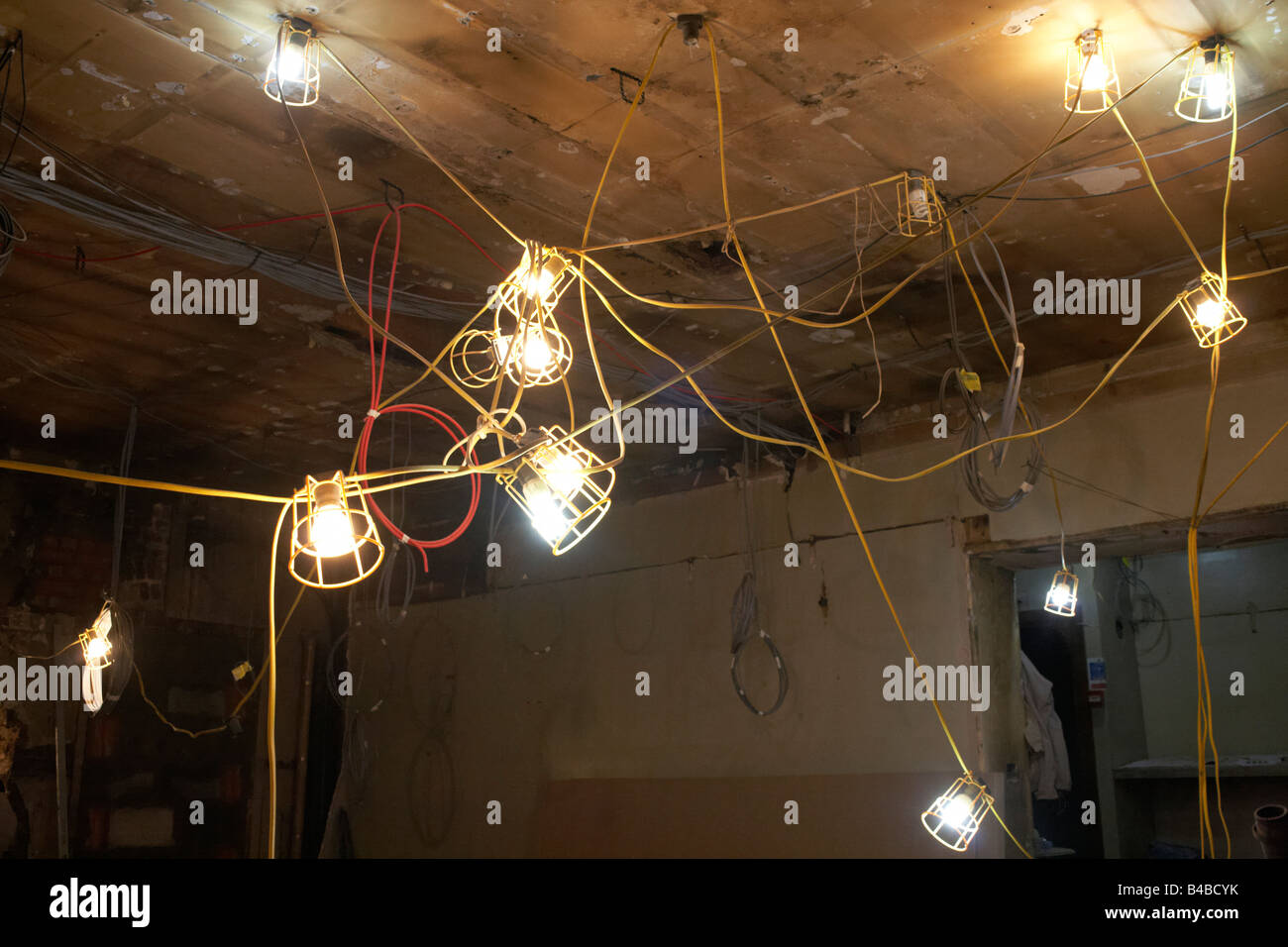 A tangle of electric lights are strung together on the ceiling of a West End restaurant  construction site in London's Soho Stock Photo