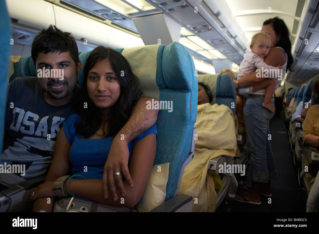 Honeymoon couple on their return home after a holiday in the Maldives return home in economy class happy Stock Photo