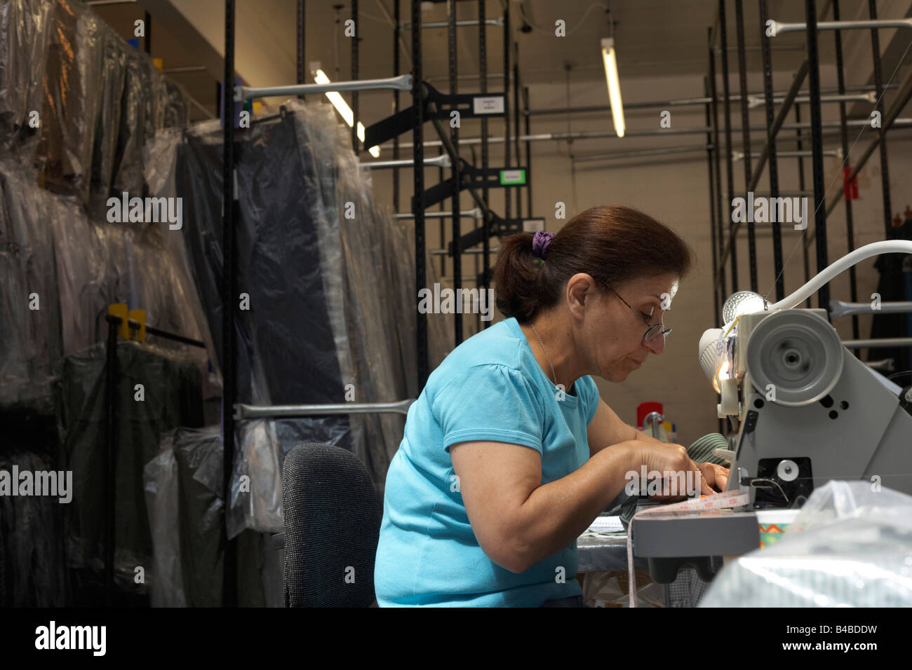 A seamstress runs up garments on a sewing machine at couturier Margaret