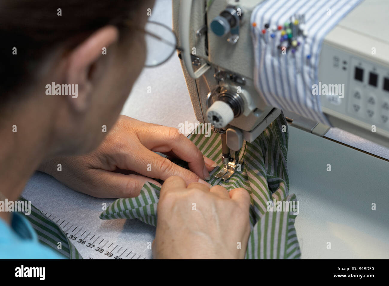 Detail of a seamstress runningup garments on a sewing machine at