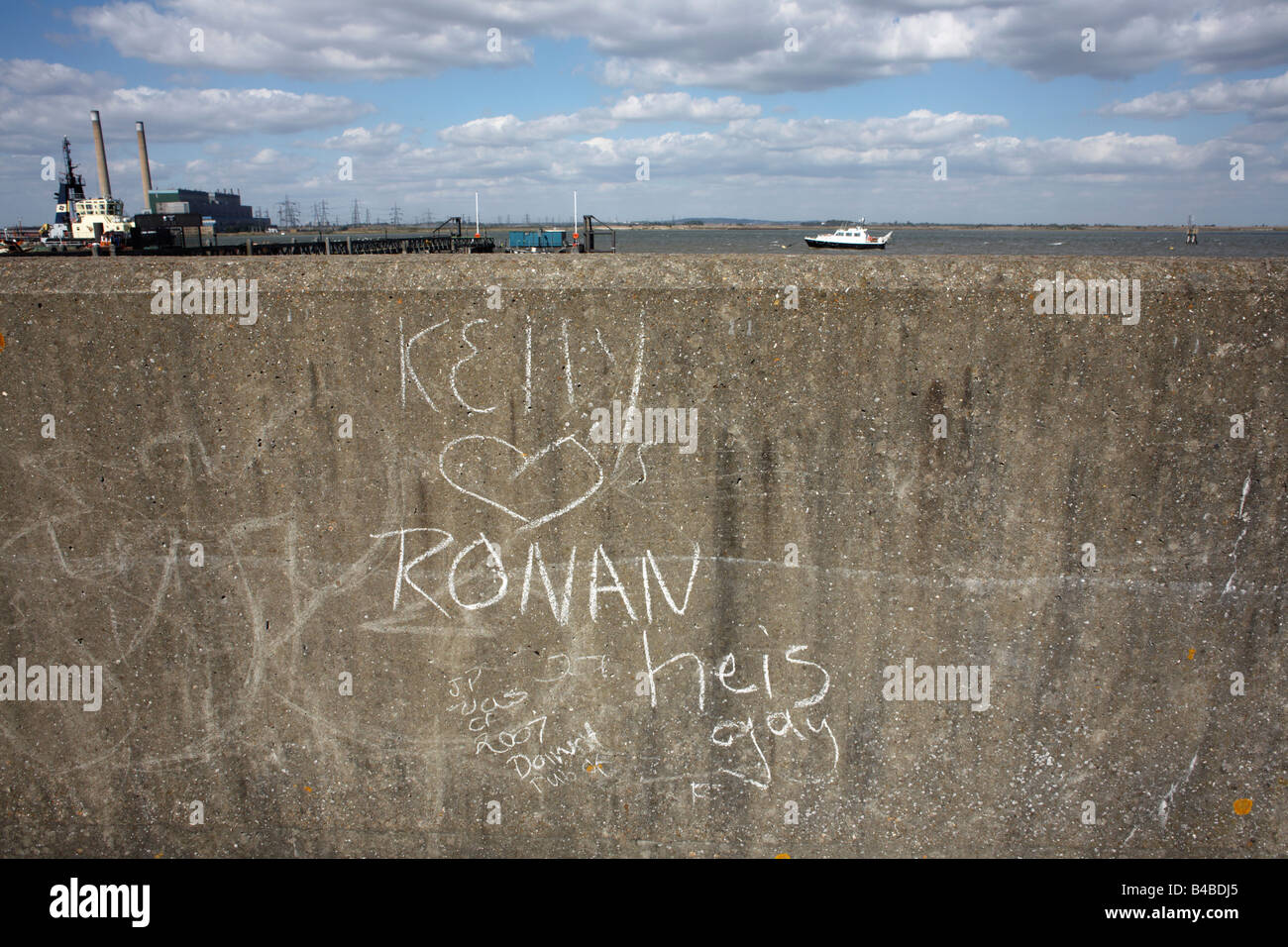 Teenage love graffiti has been written in chalk on the Thames flood wall located on the Saxon Shore Way at Gravesend Stock Photo