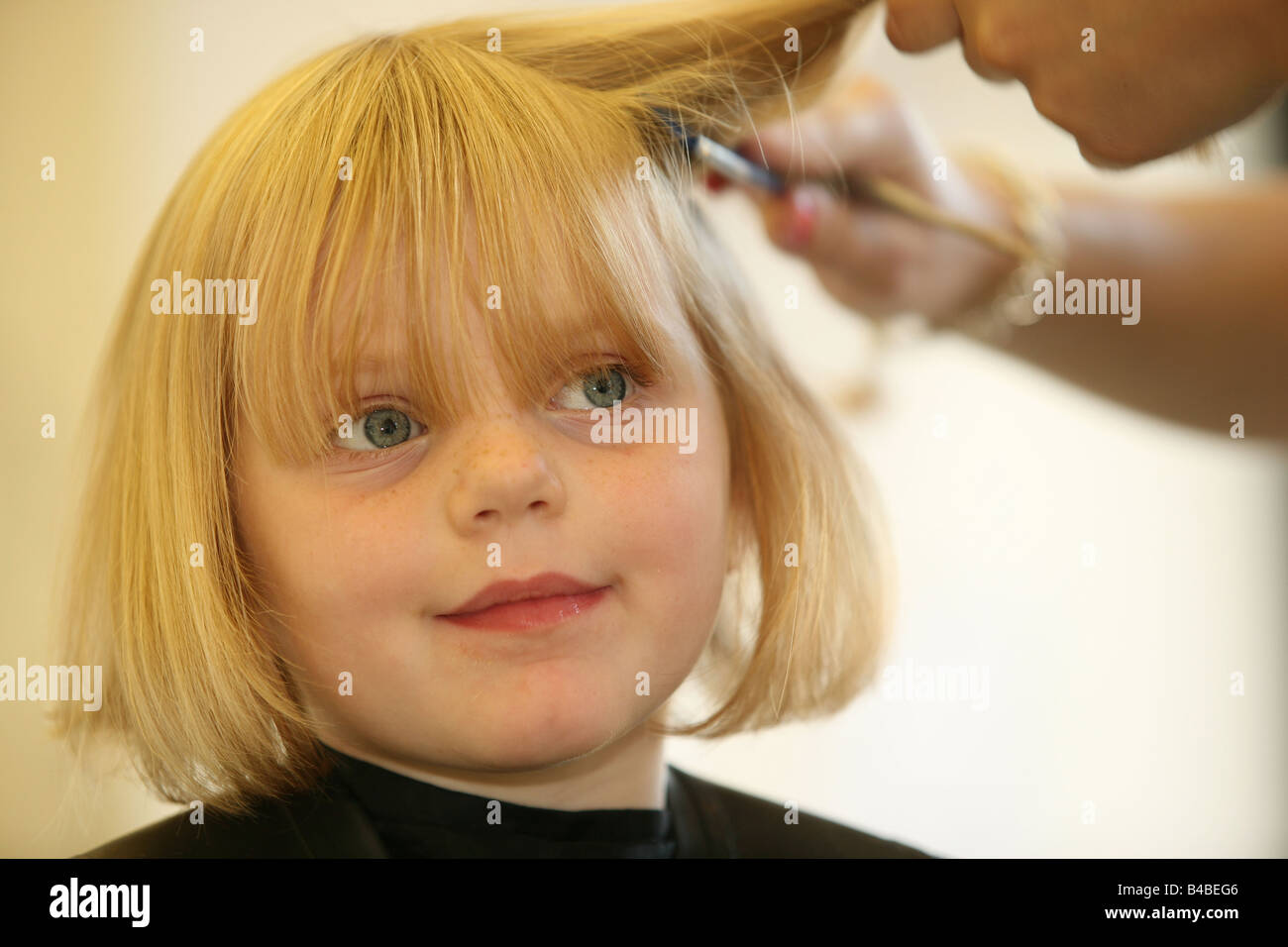 A Young Girl Having Her Haircut At A Hairdressers Stock