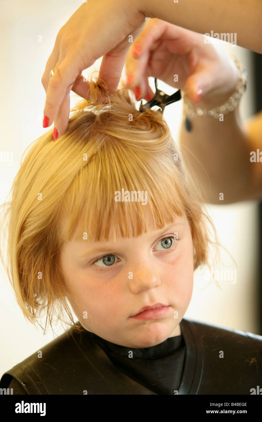 a young girl having her hair cut at a hairdressers Stock Photo