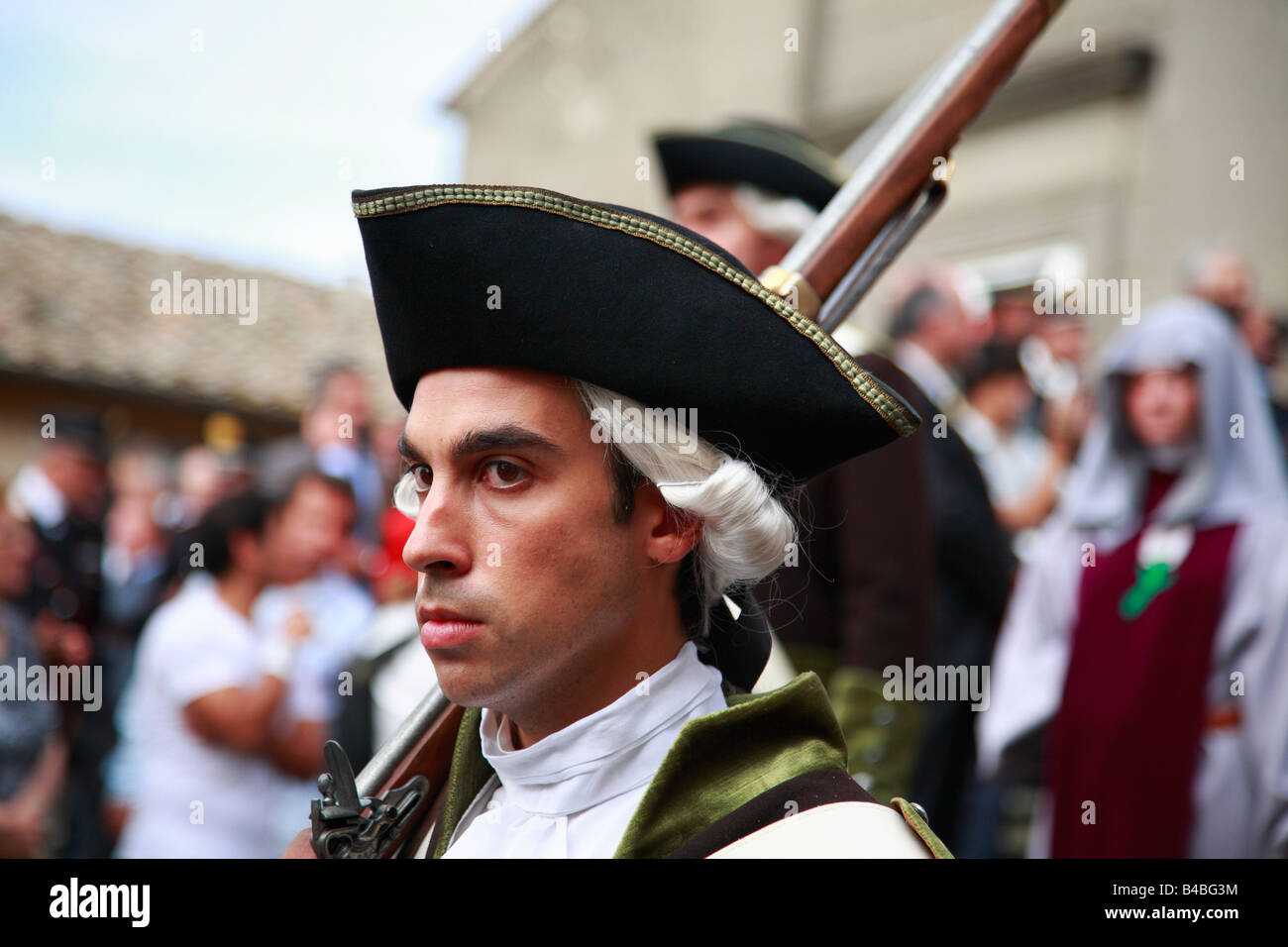 young man in 18th century military uniform with musket and tricorn hat Stock Photo