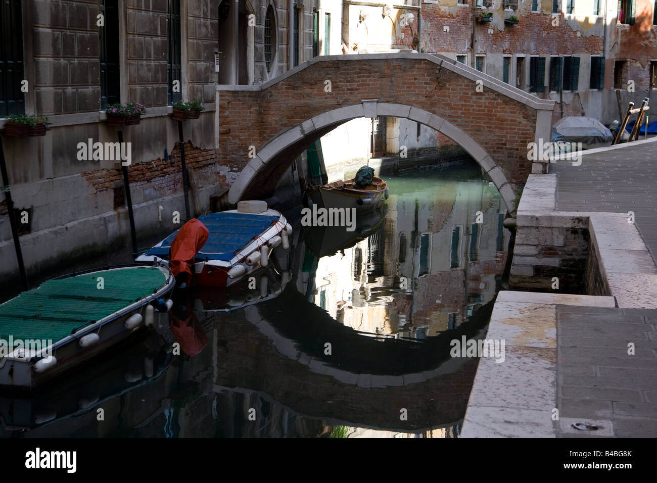 Venetian canal with bridge reflection Stock Photo - Alamy