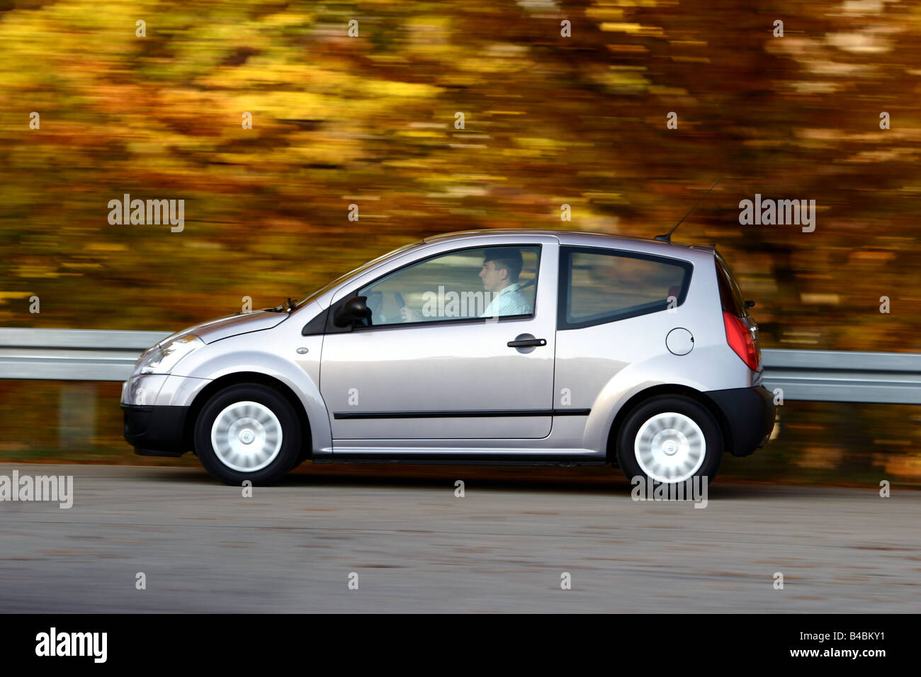 Car, Citroen C2 1.4 HDi SX, model year 2003-, silver, Miniapprox.s, Limousine, FGHDS, driving, side view, country road Stock Photo