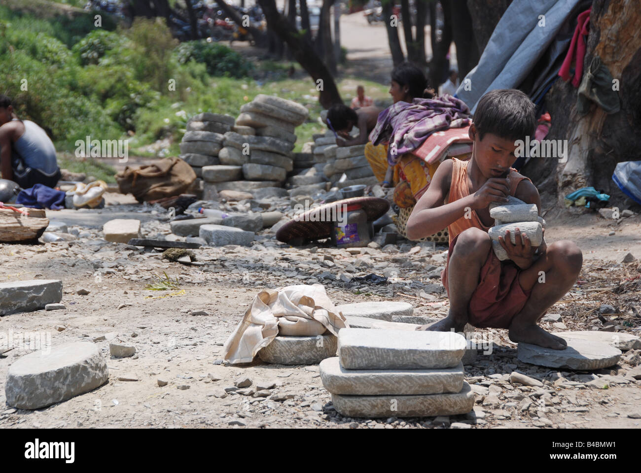 Small nepalese boy works hard with stones in suburbs of Kathmandu Stock Photo