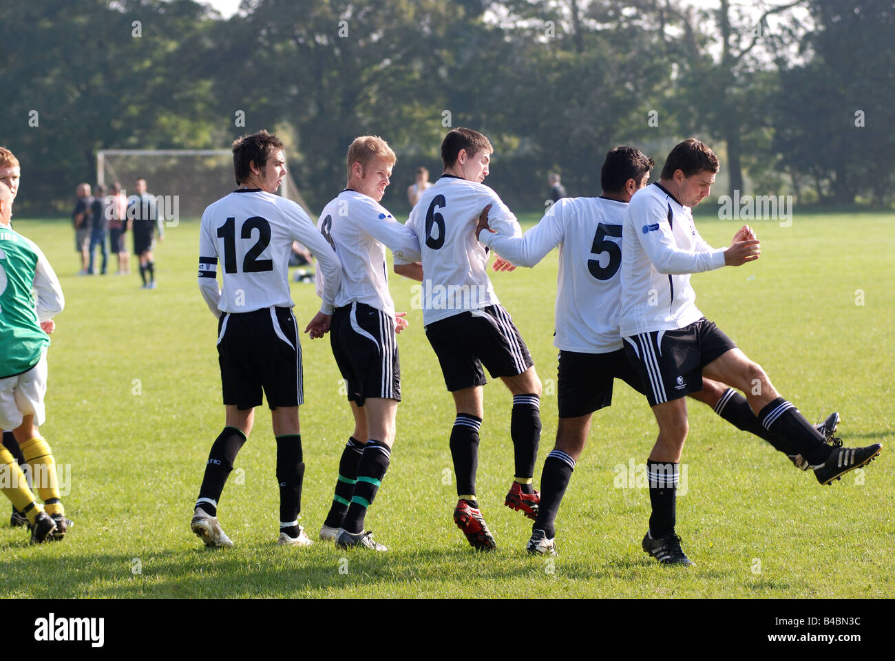 Foto Stock Football Players Standing in a Wall During Free Kick. Soccer  Players in White Sports Jersey Shirts with Black Numbers on Back.  Footballers in Turf Cleats. Soccer Teenage Boys in a