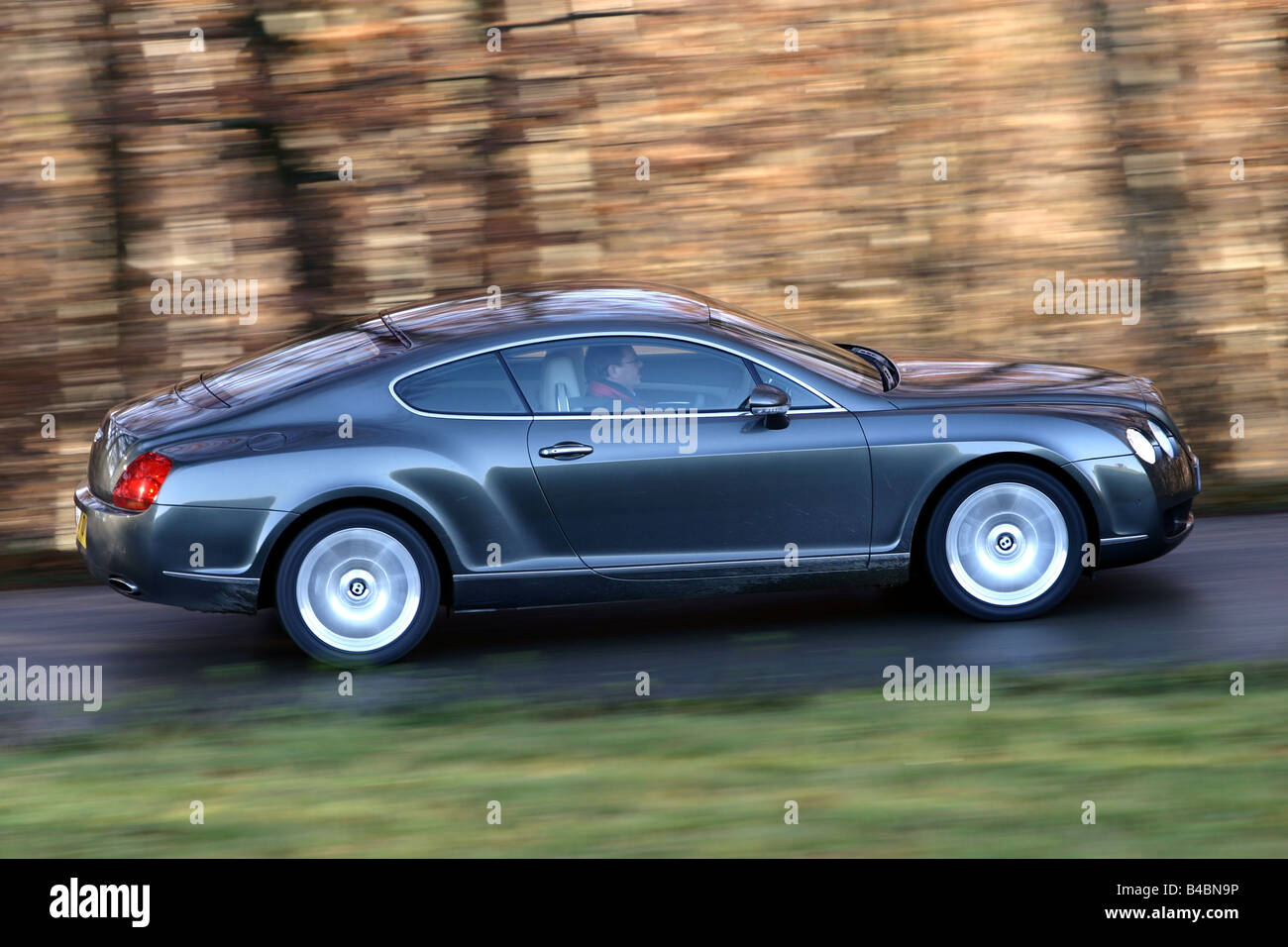 Car, Bentley Continental GT, Luxury approx.s, model year 2003-, anthracite, coupe/Coupe, FGHDS, driving, side view, country road Stock Photo
