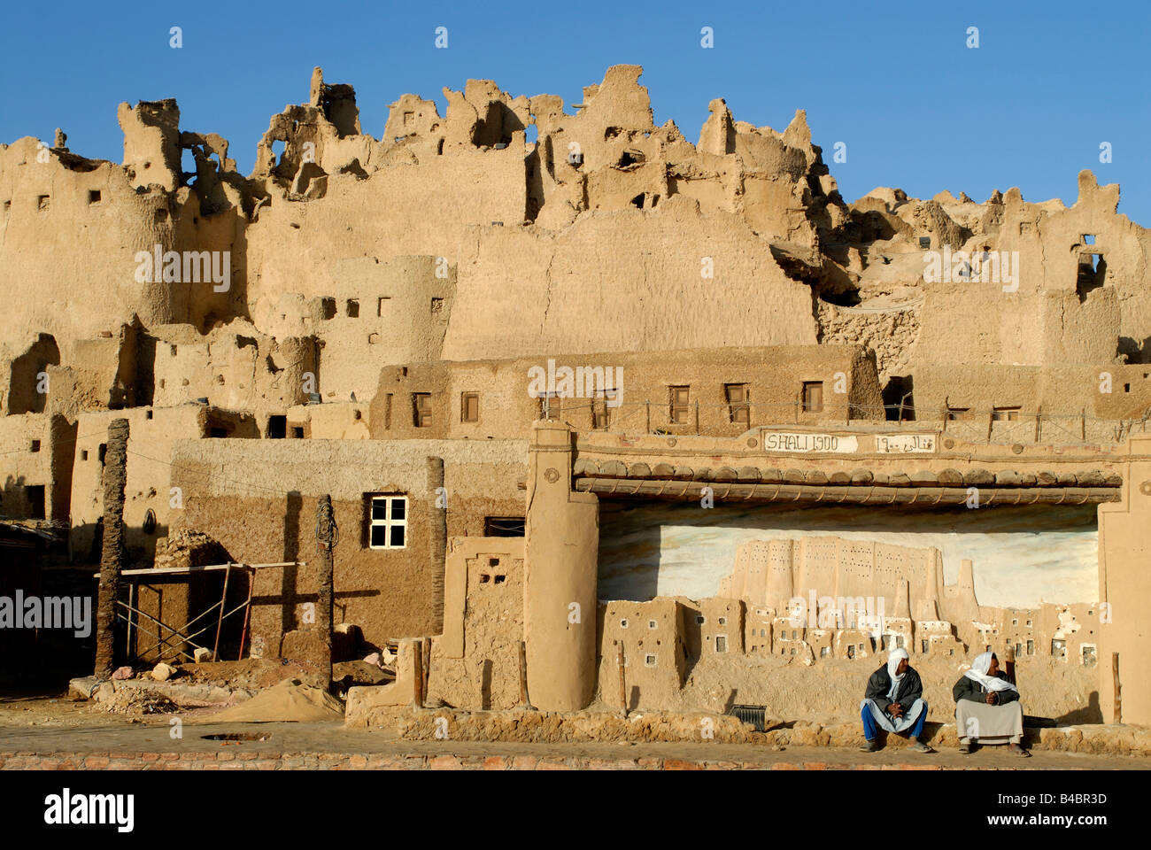 Two men sitting in front of the old town of Shiwa Egypt 2007 Stock Photo