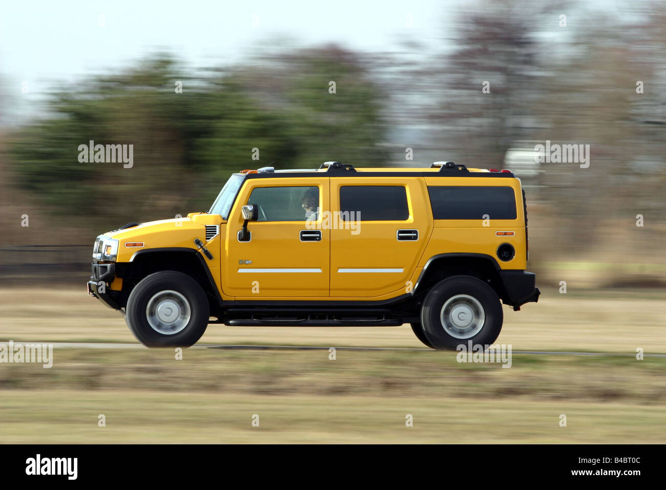 Car, Chevrolet Hummer H2, cross country vehicle, model year 2001-, yellow, driving, side view, country road, photographer: Hans Stock Photo