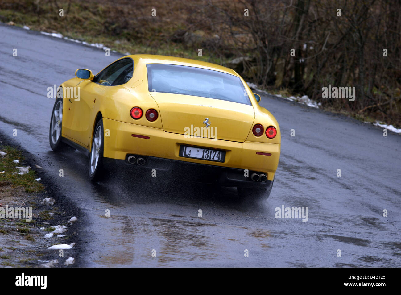 Car, Ferrari 612 Sapprox.lietti, roadster, model year 2004-, coupe/Coupe, yellow, driving, diagonal from the back, rear view, Cu Stock Photo