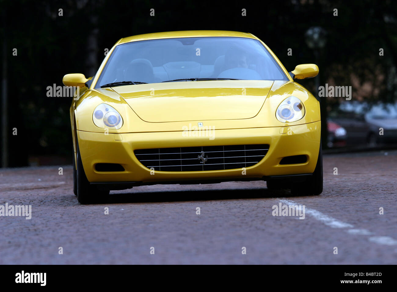 Car, Ferrari 612 Sapprox.lietti, roadster, model year 2004-, coupe/Coupe, yellow, driving, frontal view, country road, photograp Stock Photo