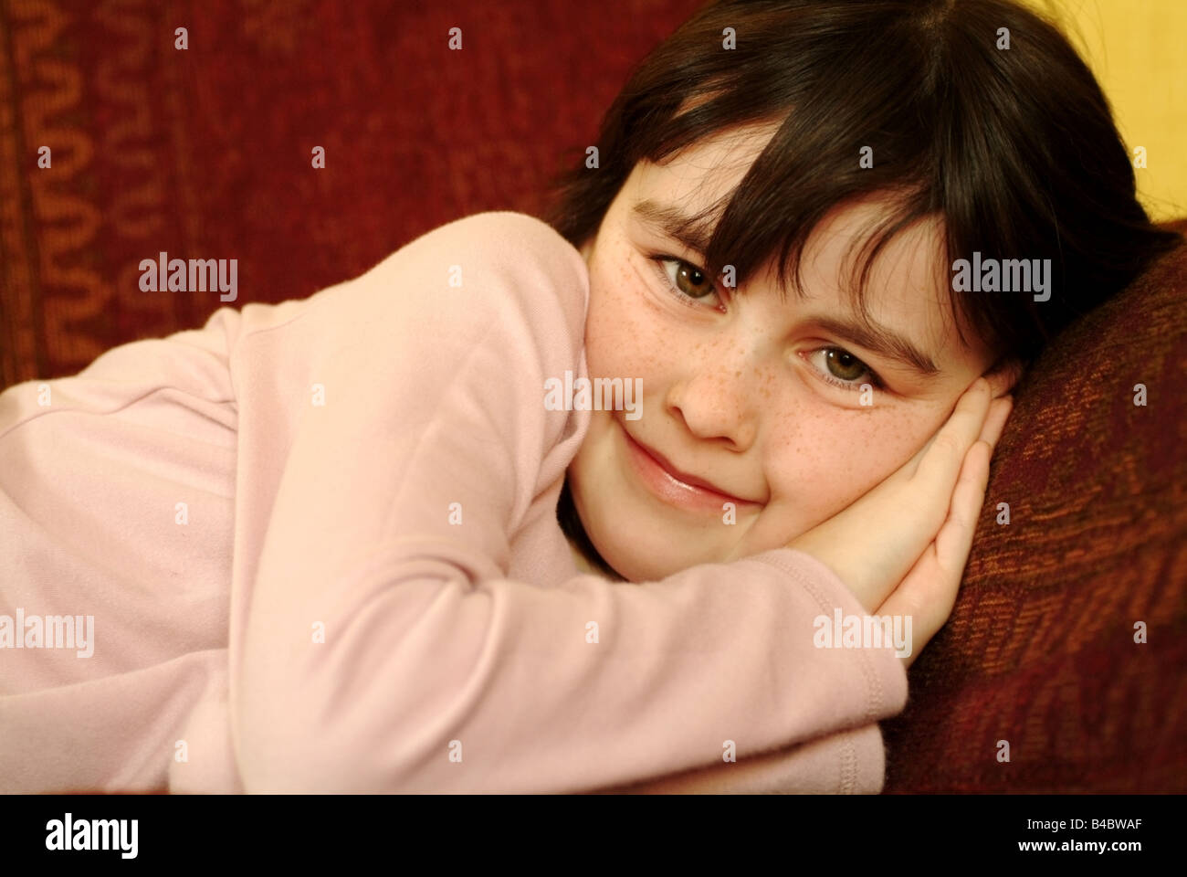 A girl relaxing at home on the sofa and smiling Stock Photo - Alamy