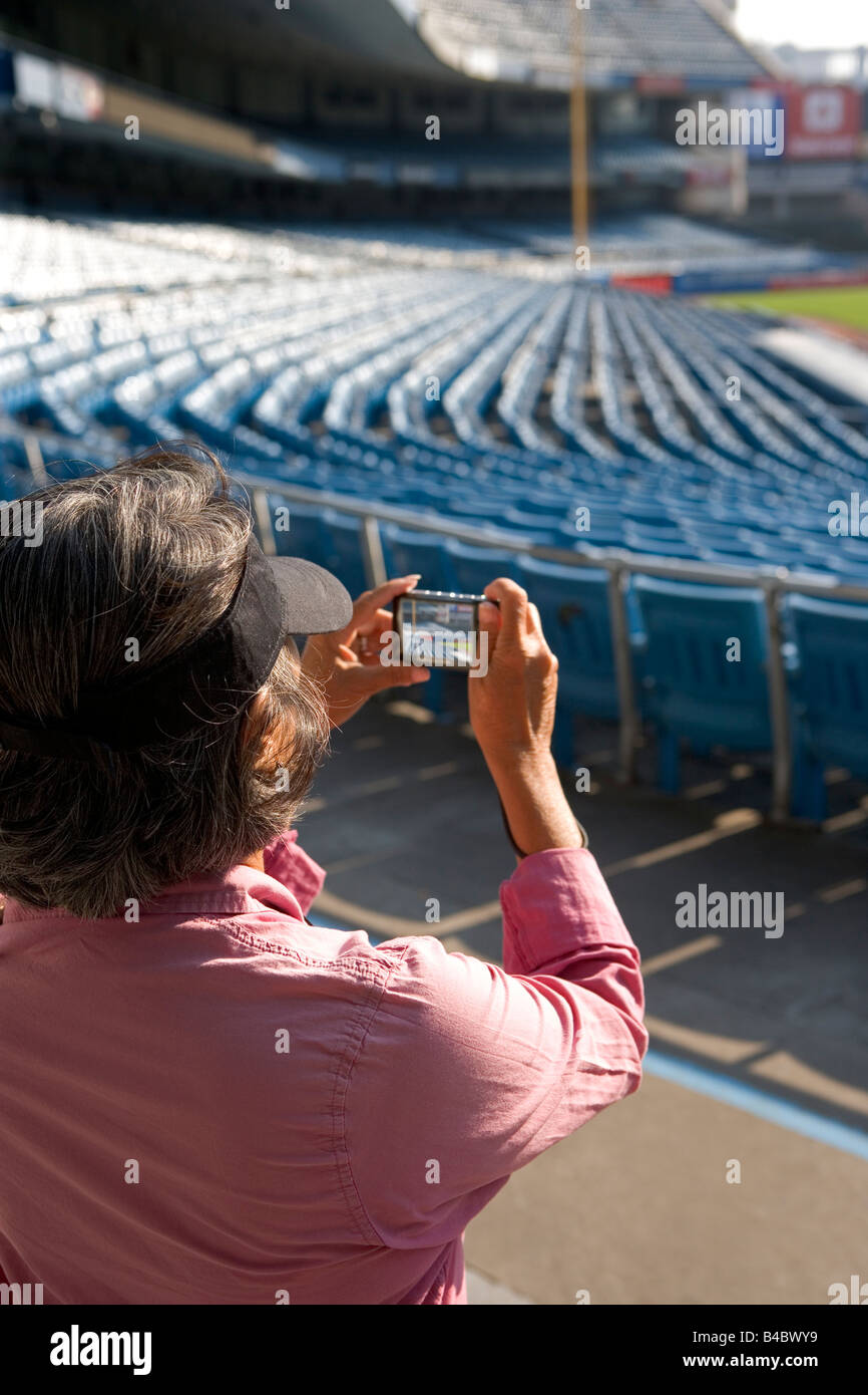 A woman tourist takes a snapshot of Yankee Stadium in the last month of its use in September 2008. Stock Photo