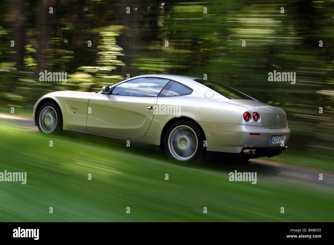 Car, Ferrari 612 Sapprox.lietti, roadster, model year 2004-, silver, coupe/Coupe, driving, diagonal from the back, rear view, si Stock Photo