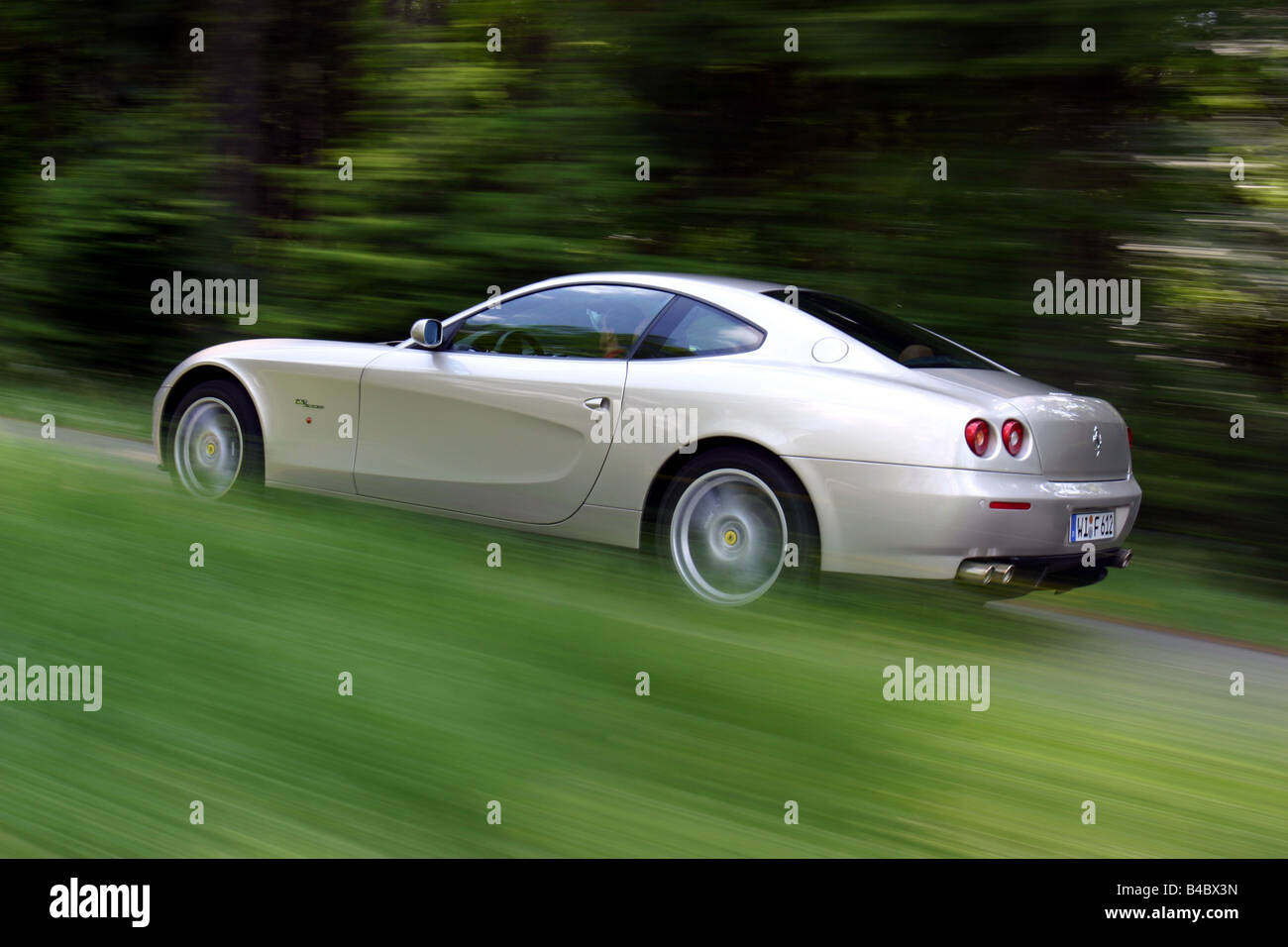 Car, Ferrari 612 Sapprox.lietti, roadster, model year 2004-, silver, coupe/Coupe, driving, diagonal from the back, rear view, si Stock Photo
