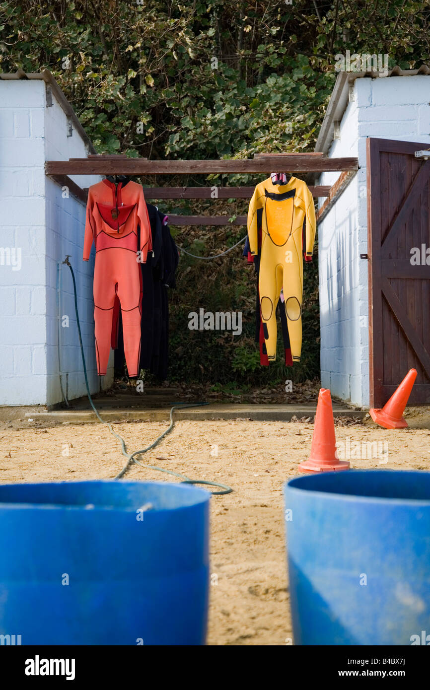 wetsuits hanging in the isle of wight Stock Photo Alamy