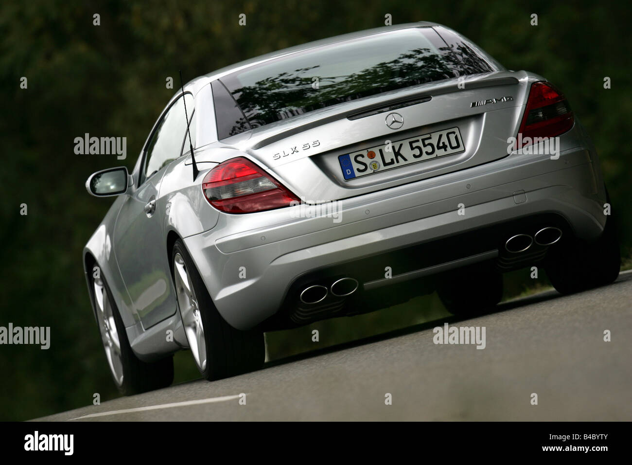 Car, Mercedes SLK 55 AMG, Convertible, model year 2004-, silver, open top, driving, diagonal from the back, rear view, country r Stock Photo