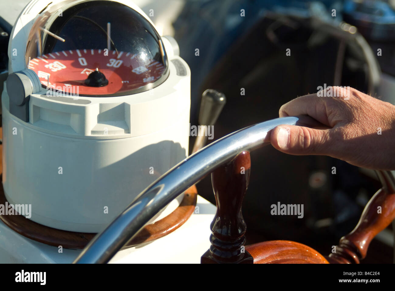 a man taking a rudder wheel and a compass Stock Photo - Alamy