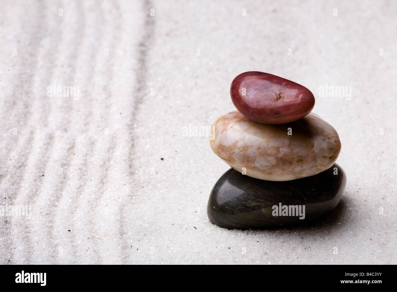 A stack of rocks in a zen rock garden with sand Stock Photo - Alamy