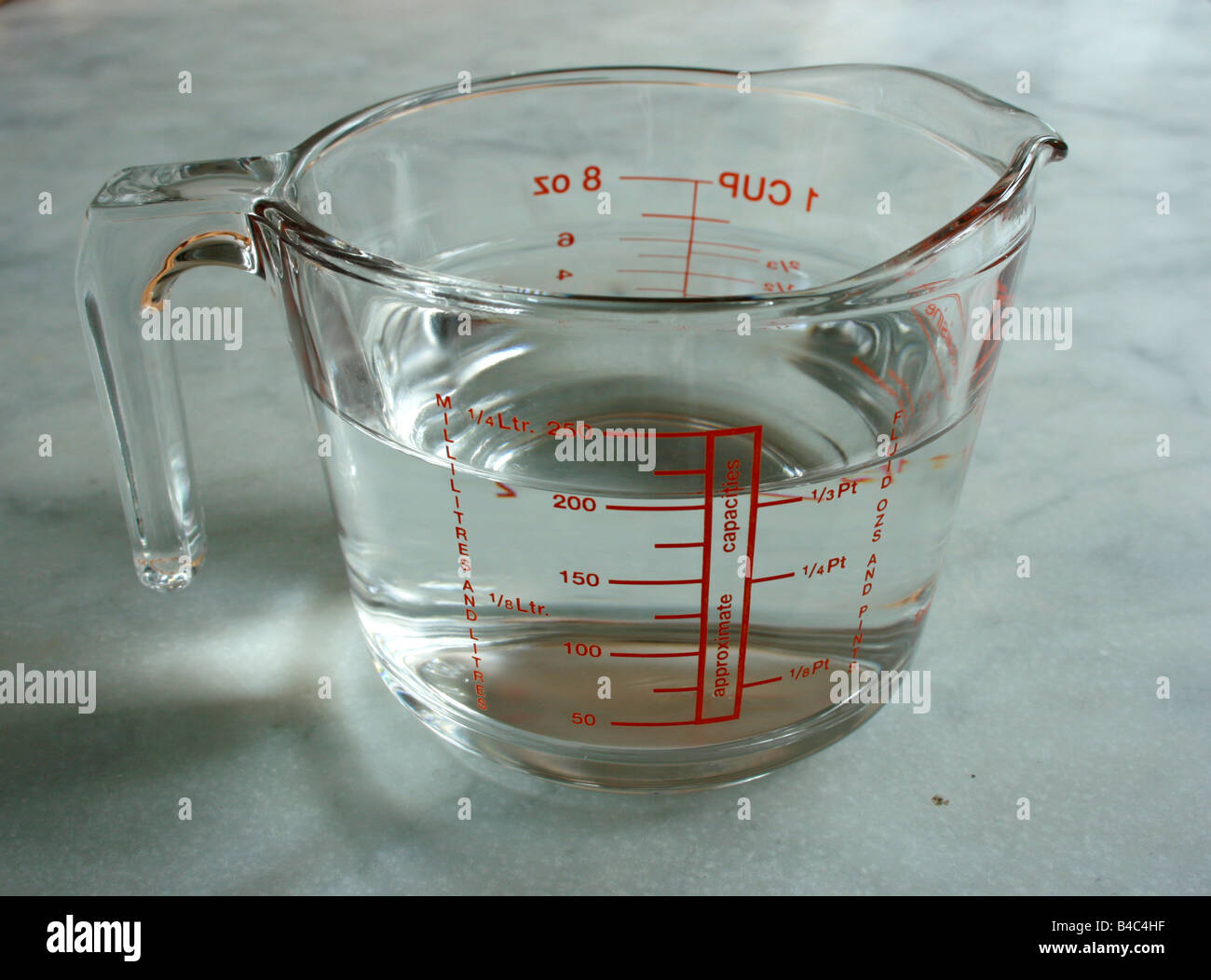 A pyrex jug containing water, viewed from the side. Stock Photo