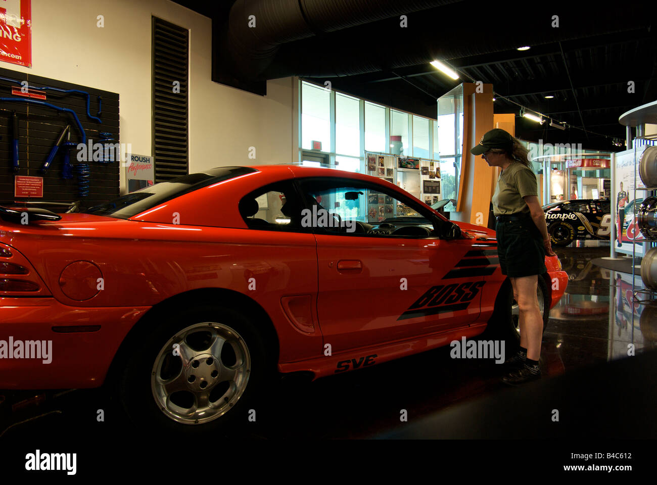 Woman admiring a Ford Boss Mustang race car at the Roush Fenway Racing museum Stock Photo