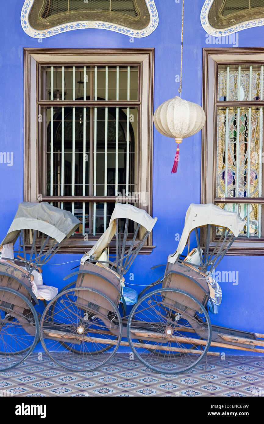 Asia, Malaysia, Penang, Pulau Pinang, Georgetown, Chinatown district, detail of Trishaws lined up against a blue painted wall Stock Photo